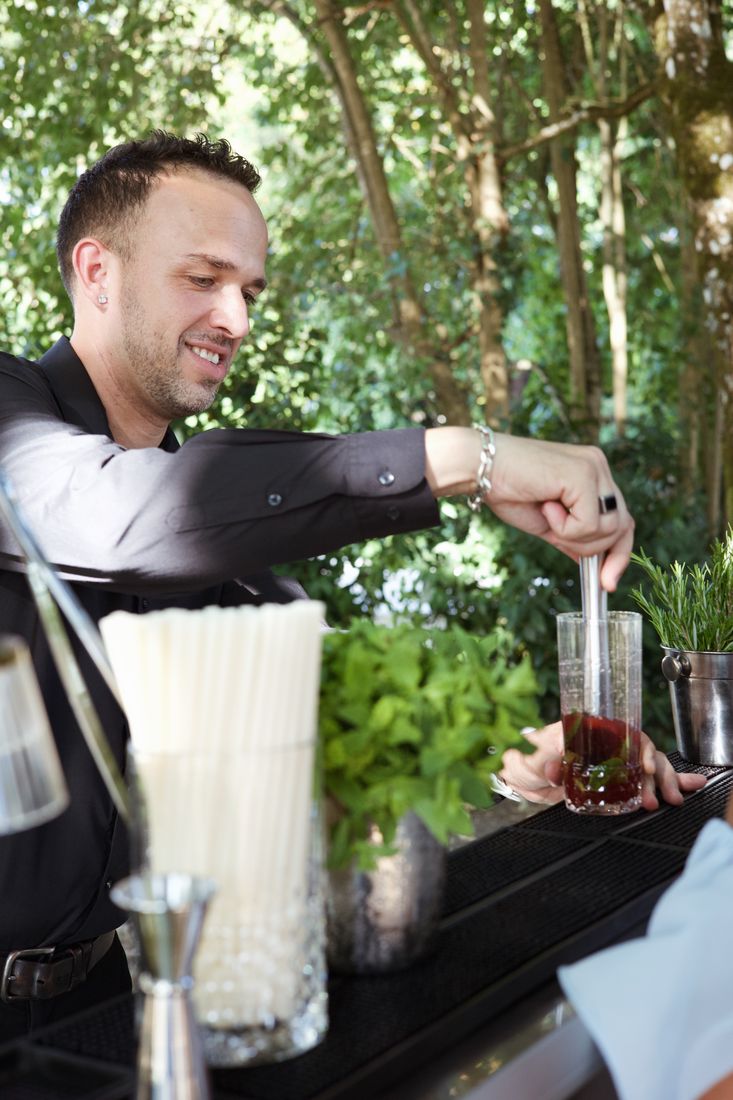 Mixologue préparant un cocktail au shaker lors d'une réception privée